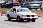 A little blurry white 87 Cutlass.